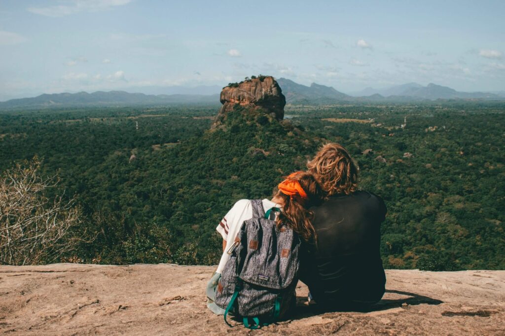 couple overlooking forest rock
