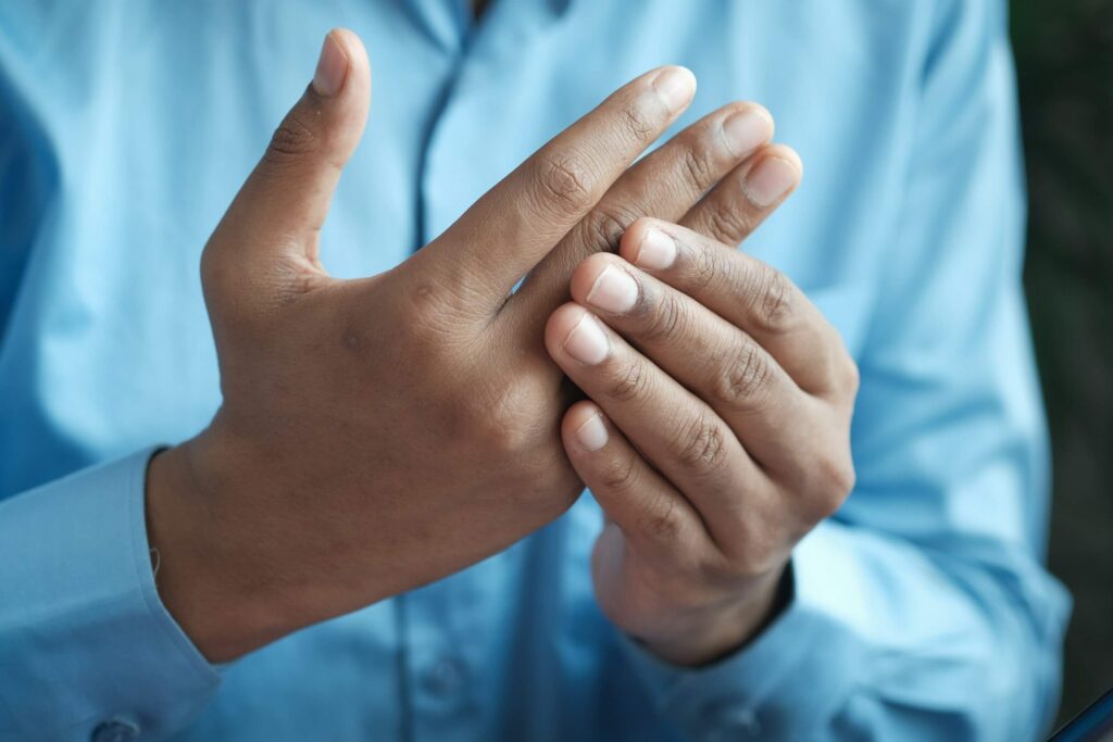 man holding sore hand man holding sore hand